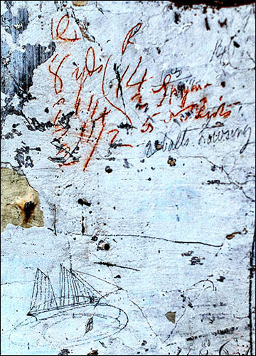 Photo of sail calculations and ship on wall inside warehouse